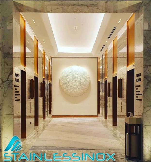 Luxurious hotel lobby with marble floors and a large circular light fixture