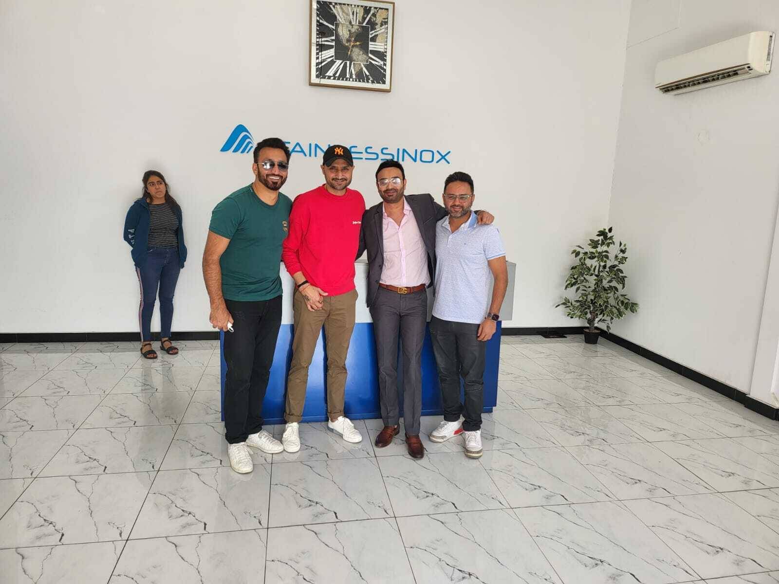 Four men standing in front of a blue table