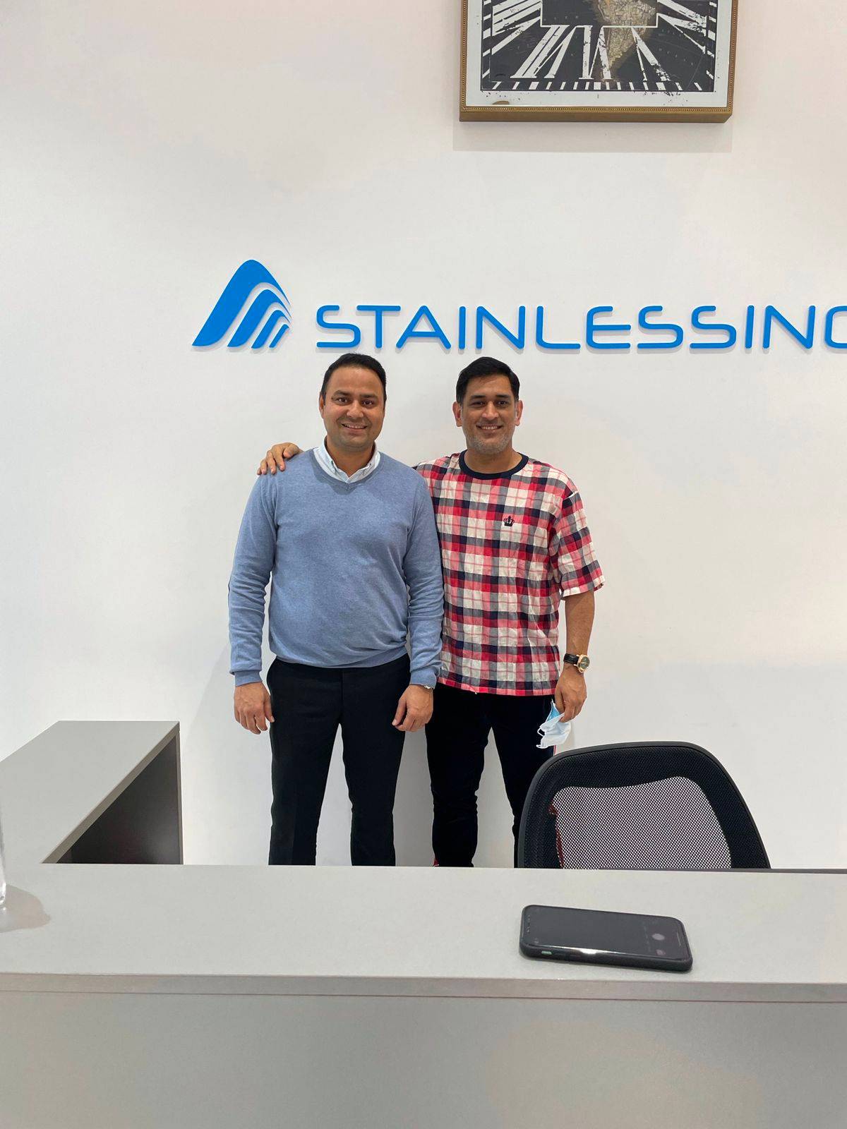 Two men standing in front of a desk with the word 