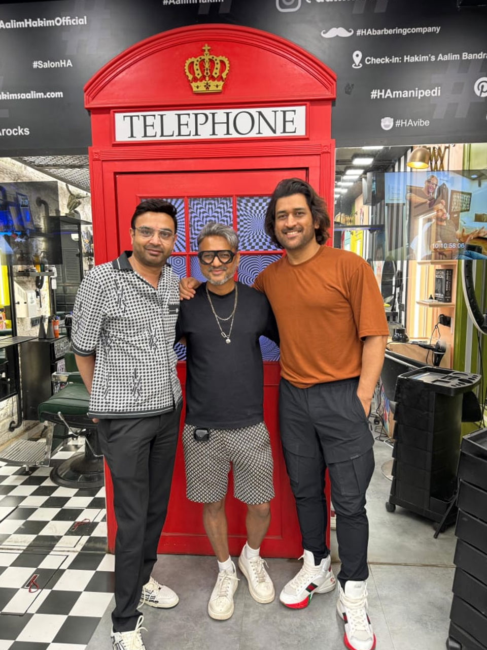 Three men standing in front of a telephone booth