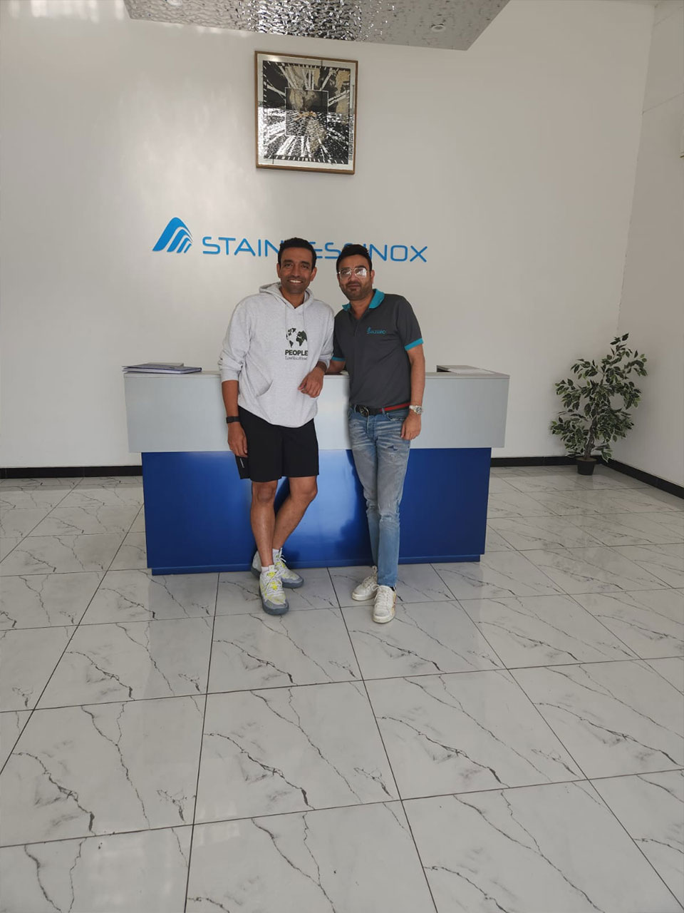 Two men standing in front of a blue table