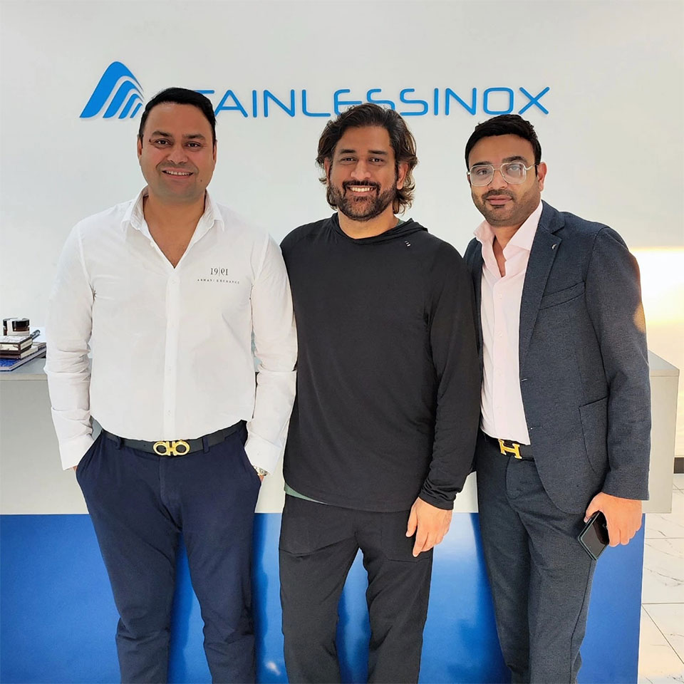 Three men standing in front of a blue table